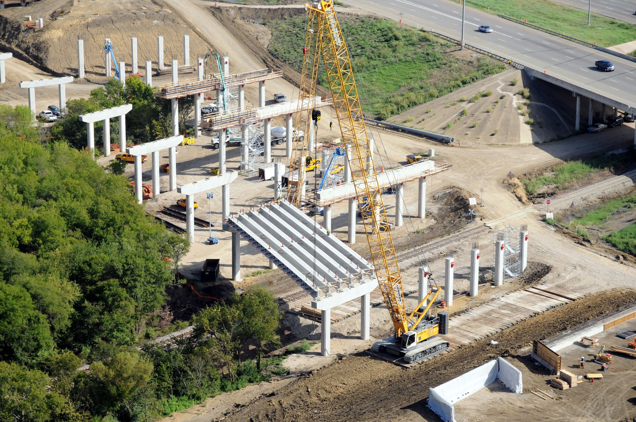 Aerial view of construction crane on a construction site of a highway bridge overpass 